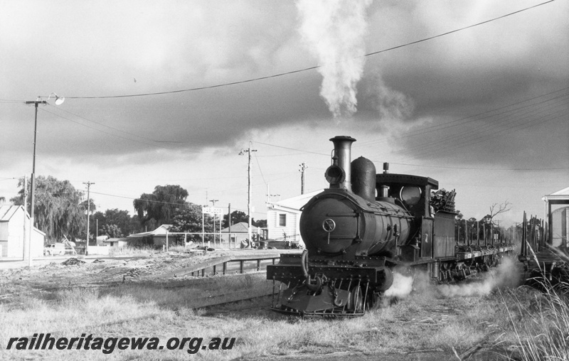 P02900
G class 71 steam locomotive, station buildings, nameboard, passenger platform, consist of timber trucks, front and side view, Yarloop, SWR line.
