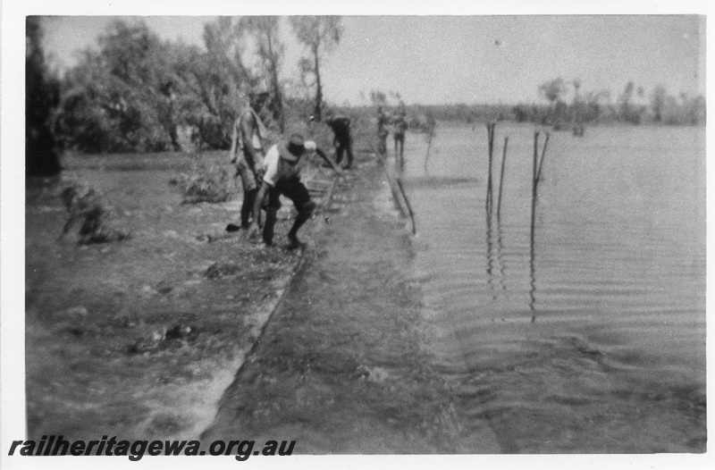 P03381
Washaway on the PM line, the Shaw river in flood, view along the track with workers 
