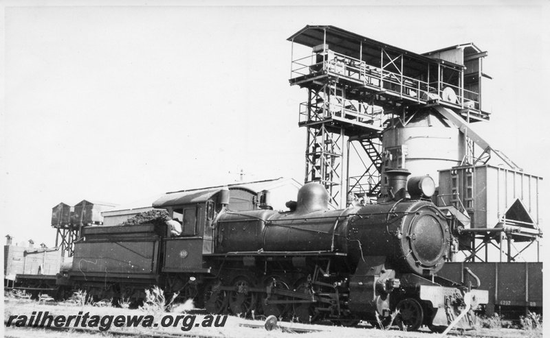 P03400
FS class 416 steam locomotive, driver on the footplate, side and front view, twin and roofed water towers, coaling plant, cheese knob, SWR line.
