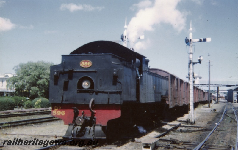 P03642
DD class 596 steam locomotive running bunker first on goods train, semaphore signals, sidings, goods shed, footbridge, signal rodding, Subiaco, ER line.
