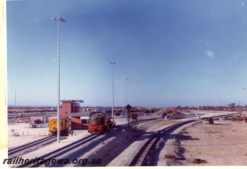 P03767
Hump marshalling yard Forrestfield, M class 1851 diesel locomotive front and side view with hump tower in the background.
