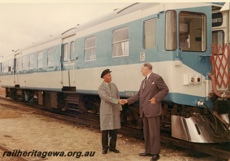 P03801
ADX class 670, blue and white livery, side and end view, two men shaking hands at track side, ER line
