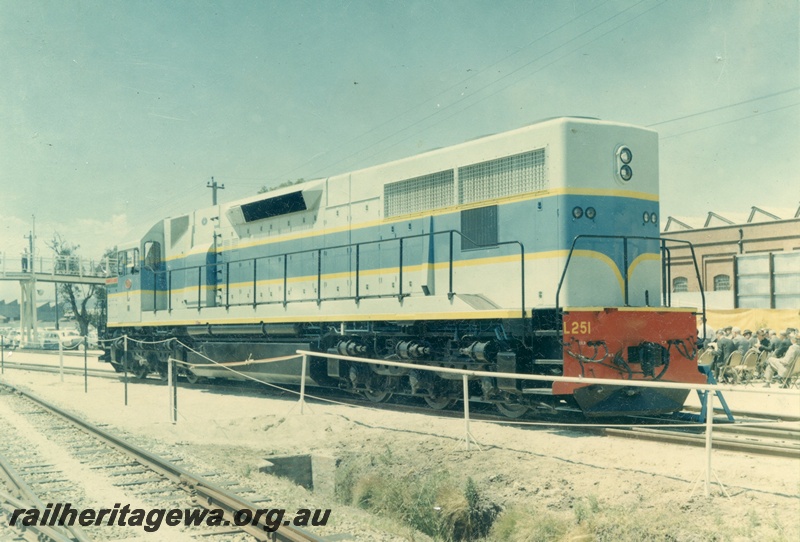 P03802
1 of 2 views of official handover of L class 251, light and dark blue with yellow lining, side and back view
