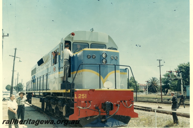 P03803
2 of 2 views of official handover of L class 251, light and dark blue with yellow lining, side and front view
