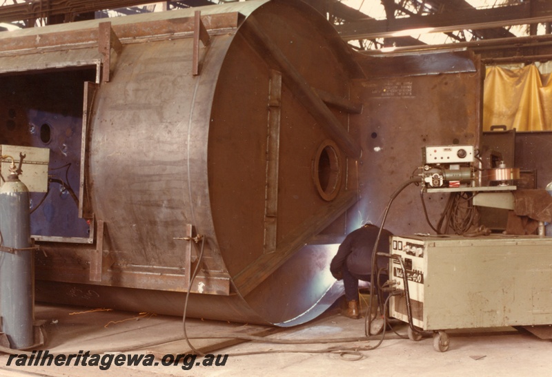 P03832
6 of 7 images of XE class wagons, under construction, Midland Workshops, wagon on side, one workman welding
