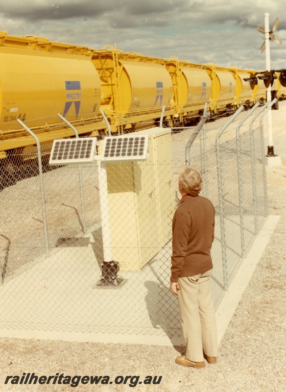 P03892
Solar panels powering the crossing lights at Eneabba, XE class ilmenite hoppers on the level crossing.
