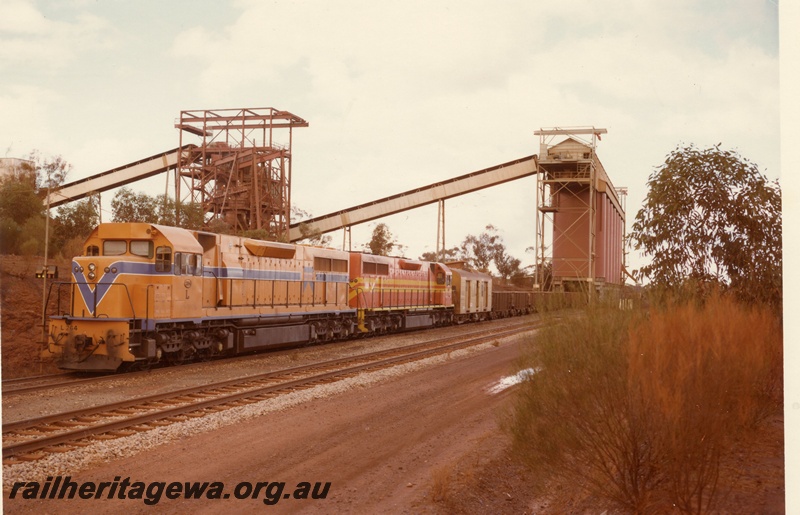 P03924
L class 264 standard gauge diesel locomotive, front and side view, in Westrail orange livery double heading another diesel locomotive in International safety orange livery, on iron ore train, WO class iron ore wagons, loading at Koolyanobbing, standard gauge line. 
