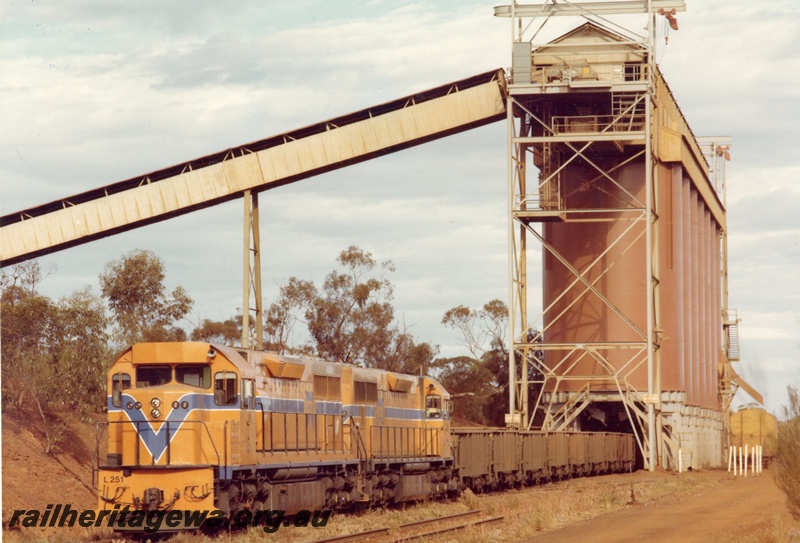 P03926
L class 251 standard gauge diesel locomotive, front and side view, in Westrail orange livery double heading another diesel locomotive in Westrail orange livery, on iron ore train, WO class iron ore wagons, loading at Koolyanobbing, standard gauge line. 
