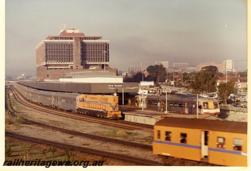 P03959
L class 256 standard gauge diesel locomotive in Westrail orange livery hauling the Indian Pacific, Prospector railcars in the dock, ADG class diesel railcar in Westrail orange livery, Perth Terminal.
