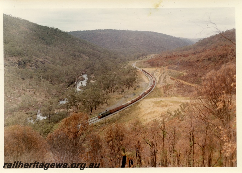 P03996
XA class diesel locomotive with red drop plate, in green with red and yellow stripe livery, on goods train, elevated view, Avon Valley. 
