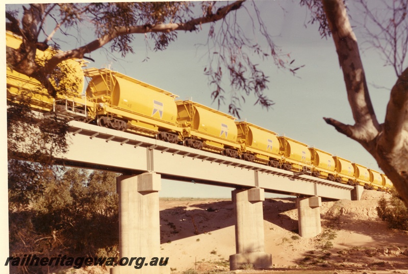 P04023
Train of XE class mineral sand wagons, crossing steel and concrete bridge, Irwin River
