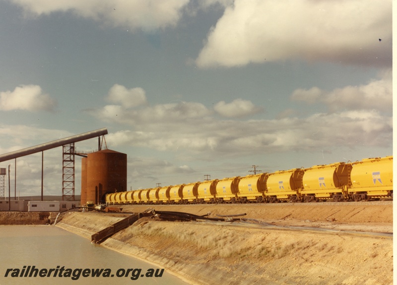 P04029
1 of 5 images, XE class wagons, loading with mineral sands, dam in foreground, Eneabba, DE line
