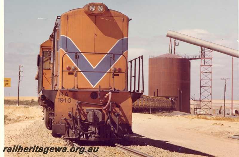 P04034
RA class 1910, Westrail orange with blue and white stripe, on mineral sands train, loading mineral sands, Eneabba, DE line, front view
