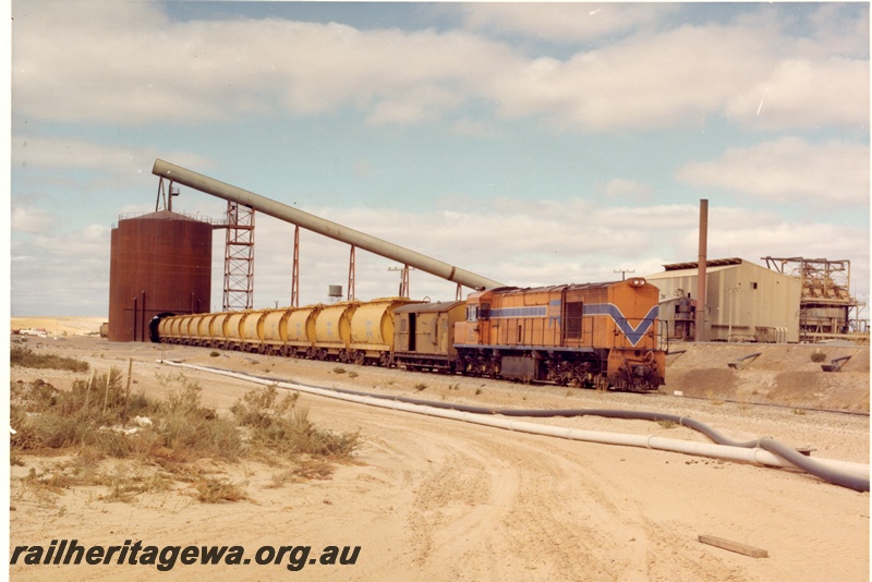 P04035
RA class 1910, Westrail orange with blue and white stripe, on mineral sands train, loading mineral sands, Eneabba, DE line, side and front view
