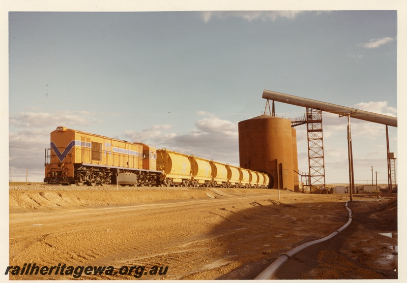 P04037
RA class 1907, Westrail orange with blue and white stripe, on mineral sands train, loading, Eneabba, DE line, view from opposite side of tracks to P4036
