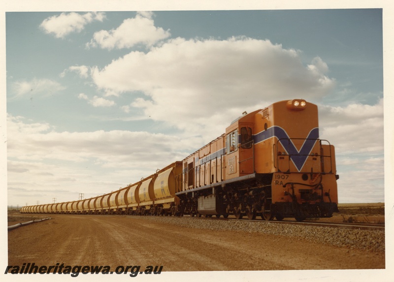 P04039
RA class 1907, Westrail orange with blue and white stripe, on mineral sands train, XE class wagons, en route to Eneabba, DE line
