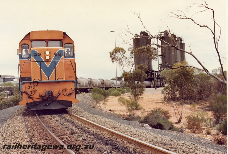 P04147
1 of 3 L class 273 standard gauge diesel in Westrail orange livery, front view, on nickel train of WNA class nickel ore wagons being loaded, Red Mine Kambalda.
