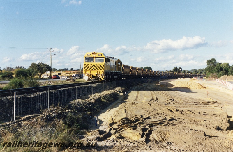 P04300
S class 2102 diesel locomotive in Westrail yellow with black chevrons livery, front and side view, on bauxite train.
