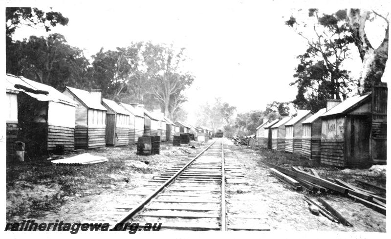 P04414
Timber worker's bush camp, rows of huts alongside the railway line, view along the line.
