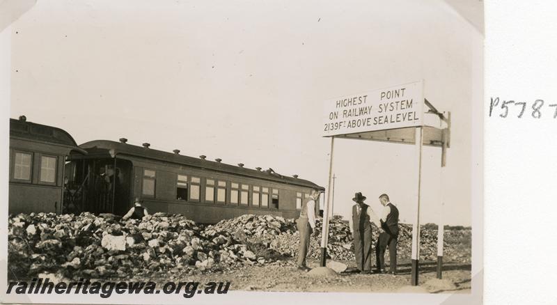 P05787
AM class 313 Ministerial carriage, part view of an AG class Inspection carriage at  Paroo, NR line, crew/officials standing underneath a large sign stating that this is  the 