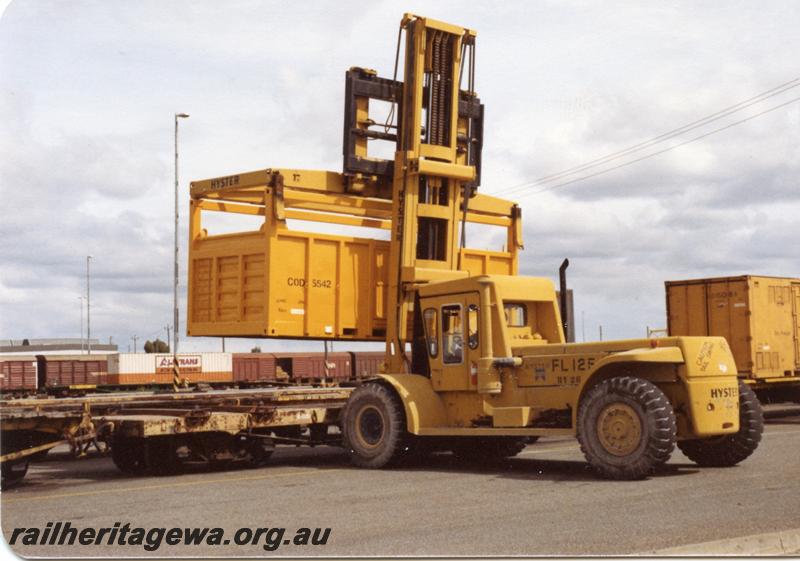 P05883
COD class container being loaded on a flat wagon by a heavy lift forklift.
