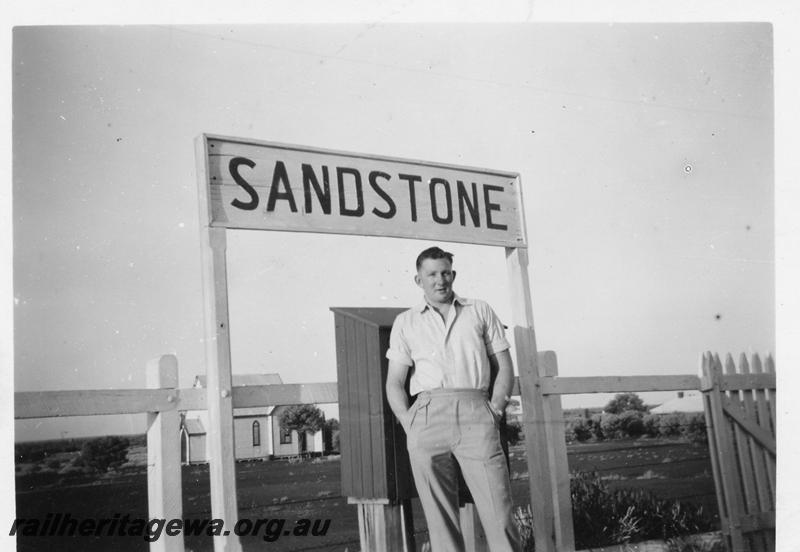 P06701
Fireman A. Livingstone photographed under the nameboard of Sandstone Station, NR line
