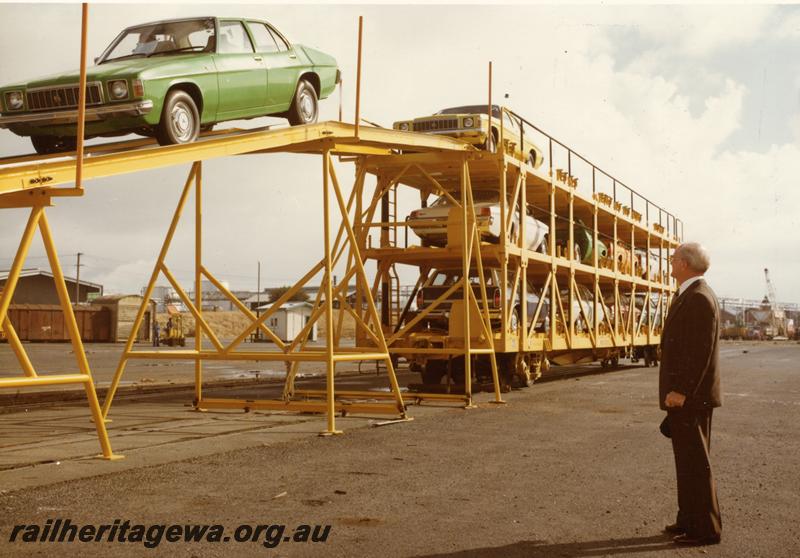 P06948
WMB class standard gauge motor vehicle carrying wagon, end and side view, car being driven off top deck onto unloading ramp.
