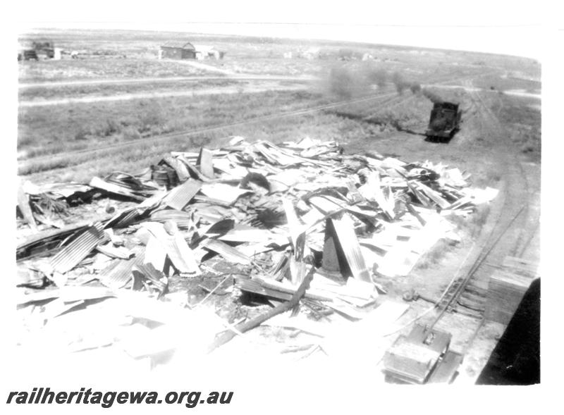 P07719
5 of 8 views of the burnt down running shed at Port Hedland, PM line on 9.10.1950, the night before the annual visit by the Chief Boiler inspector (Jack Farr), accompanied by a fitter (Ted Bosworth) and a boiler maker. G class 234 was badly damaged in the fire. View of shed debris with H class 22 in background
