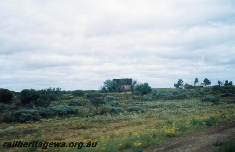 P08619
Yalgoo, water tower, barracks in background, NR line. View from a moving vehicle.
