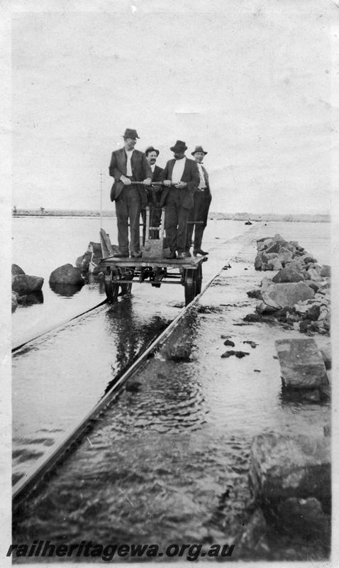 P08692
Fettlers on a Kalamazoo ganger's trolley, on flooded track, location Unknown
