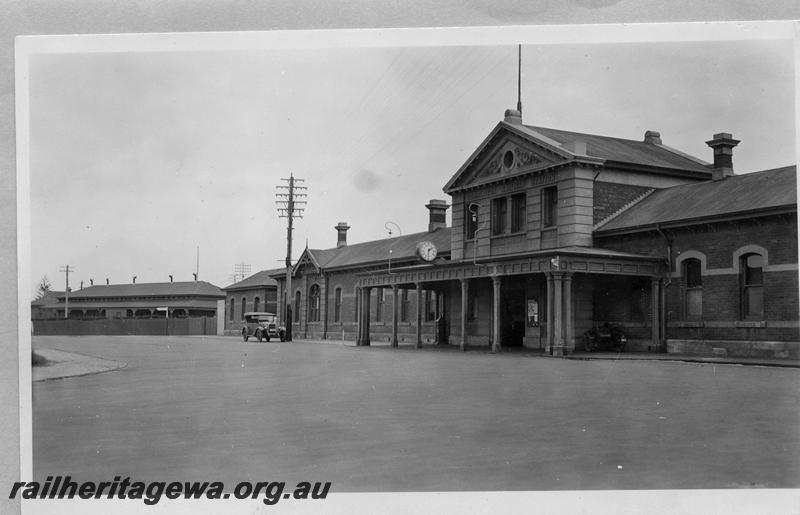 P08709
Station building, Geraldton, NR line, streetside view, shows period car in the view, the district engineers office building is in the background on the far left of the view
