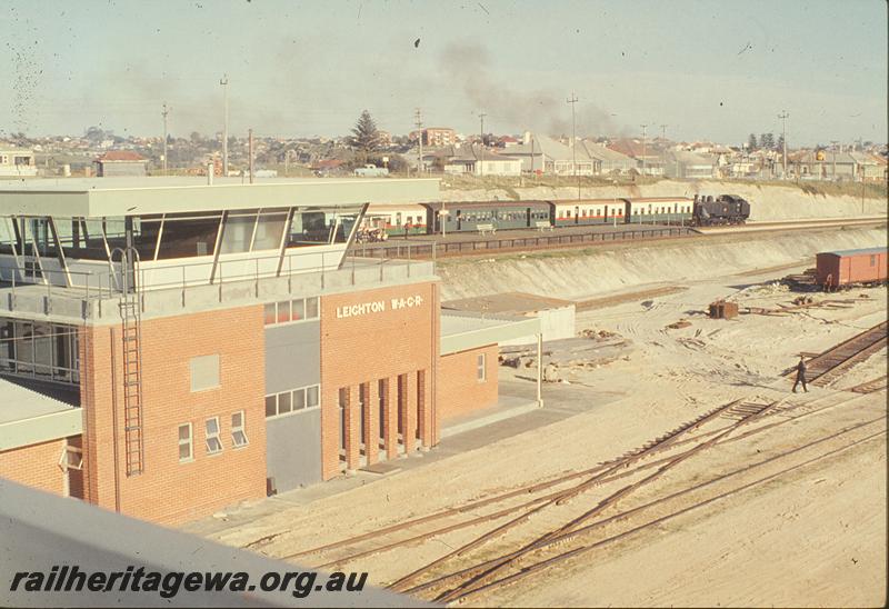 P09830
Leighton Yard, Yardmaster's Office and control tower, DD class 591 on up passenger leaving station platform, three different carriage liveries, standard gauge line laid across narrow gauge lines. ER line.
