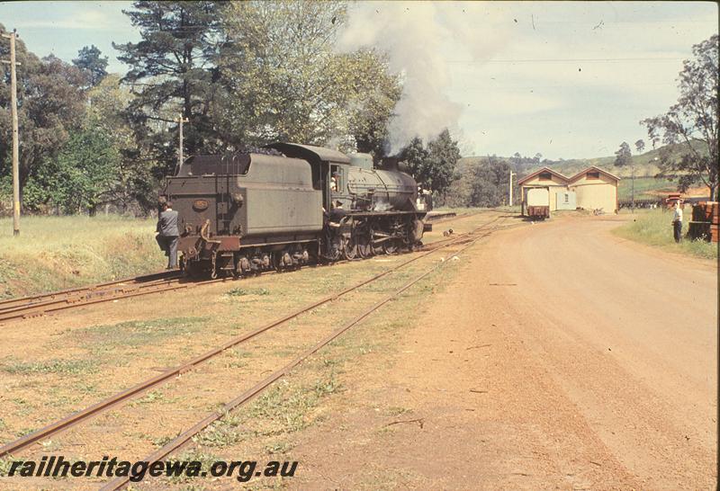 P09906
W class 953, shunting into loop, goods shed, down home signal visible in distance, guard riding on loco steps, station master riding tender steps, part of station building, platform visible, trestle in distance, Balingup. PP line.
