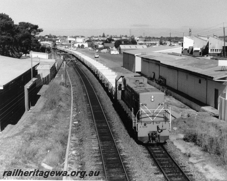 P10343
A class 1514 diesel locomotive in Westrail orange livery, long end leading, hauling rake of four wheel empty open wagons, passing Subiaco. Rails in yard have been removed.
