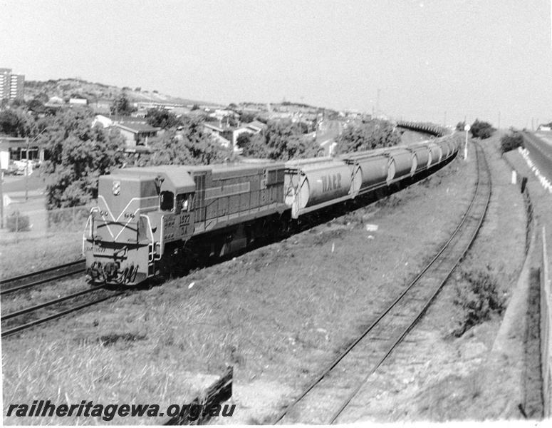 P10366
DA class 1577 Westrail Orange short end leading approaching Cottesloe Station with train of empty XW class wheat wagons bound for Avon Yard freight only Cottesloe Leighton Yard, line visible on right of train. 
