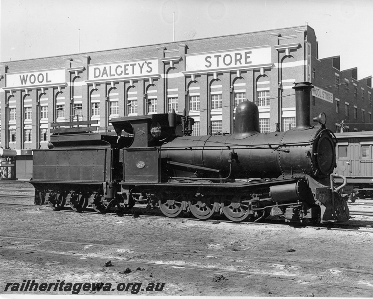 P10368
G class 67 with timber hungry boards, Fremantle Yard, side and front view, Dalgety's Wool Store behind the loco
