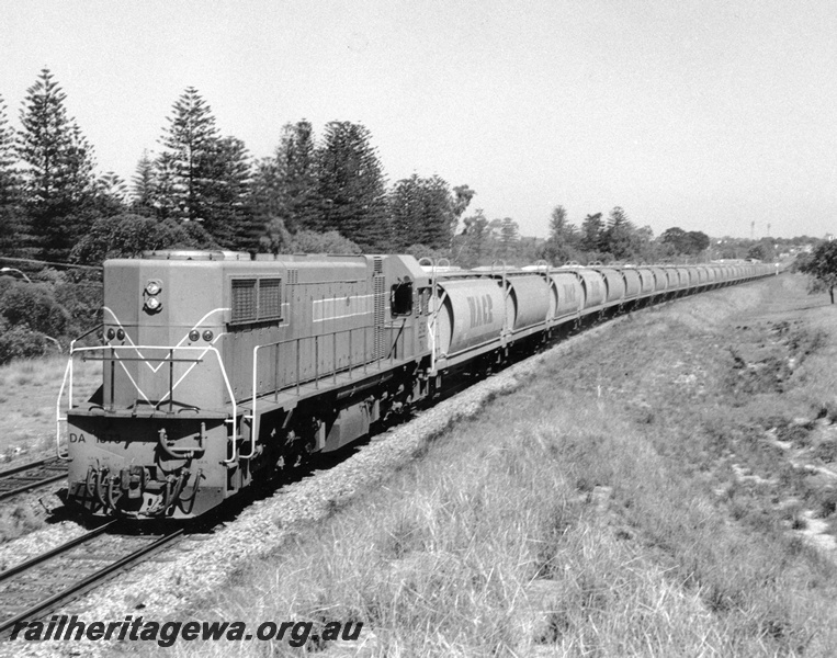 P10369
DA class 1573 Westrail Orange, long end leading Perth bound approaching Shenton Park with long train of empty XW class wheat wagons for Avon. End and side view left hand side of loco.
