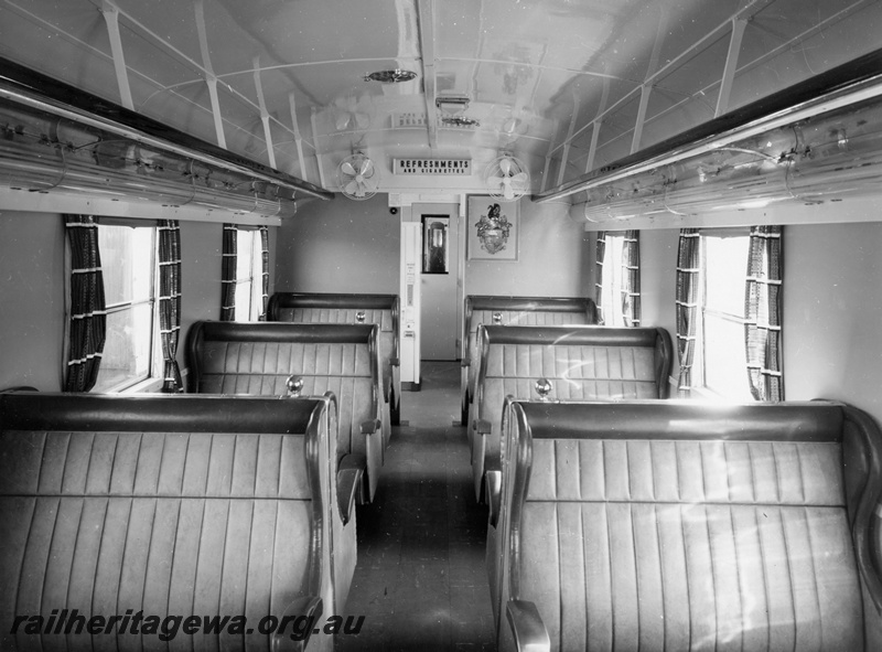 P10394
Interior view of AYU class trailer car showing window curtains, overhead luggage rack, cooling fans and entrance to refreshment vending machines. 
