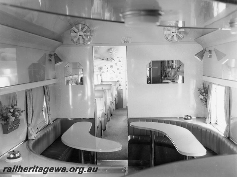 P10396
AYS class buffet car showing curved dining tables, saloon fans and portion of saloon seating. Note the wall mounted overhead lights and wall mounted mirrors.
