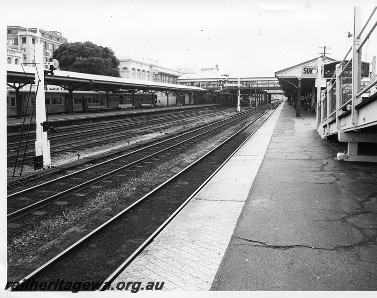 P10409
Perth Station looking in a westerly direction with portion of footbridge from Barrack street visible, Signal posts in fore and mid background. Portion of a four car ADK/ADB railcar set is noted in the Armadale dock as is the pedestrian footbridge between platforms.
