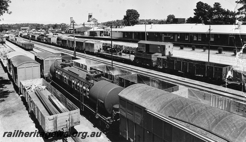 P10417
An overhead view of Narrogin railway yard, GSR line, depicting various types of wagons, loaded and empty, Flour mill is featured in the left background .
