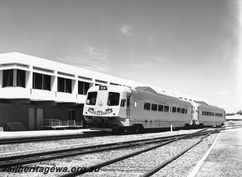 P10445
1 of 3 of Prospector 2 car set at Northam enroute to Kalgoorlie. Side views of both cars, portion of Administrative Building in background. Narrow gauge line to right is the line to Goomalling, Wongan Hills and Wyalkatchem with the standard gauge crossing this line leading to the former East Northam yard.
