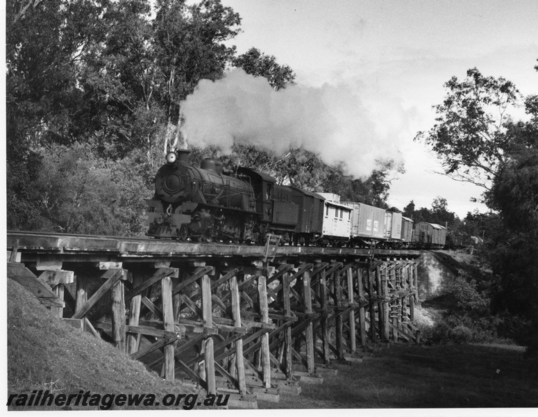 P10464
W class 902 steam locomotive in the vicinity of Capel. BB line. A VW class workman's van is marshalled behind the locomotive. Note the wooden construction of the bridge.
