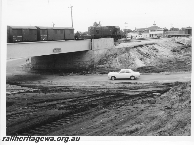 P10531
A Class 1511 diesel locomotive hauling a Down goods train to Midland passing over the Bayswater Subway and approaching the new station. In the foreground is the earthworks resulting from the removal of the former subway and station.
