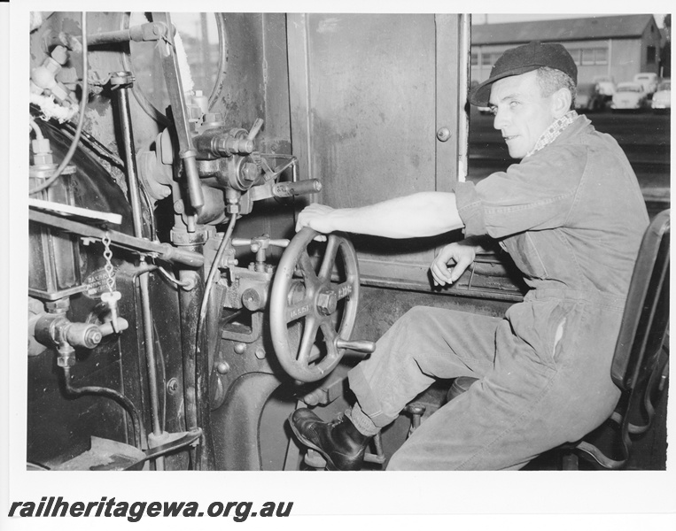 P10550
A driver dressed in overalls, at the controls of a DD/DM class steam locomotive. Notice the dress variation to P10548.
