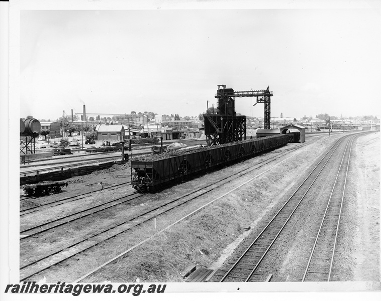 P10559
East Perth coaling stage with a rake of XA class coal hoppers waiting unloading. A wagon can be seen in the unloading shed. The two lines in the foreground are the main lines between Midland and Perth.
