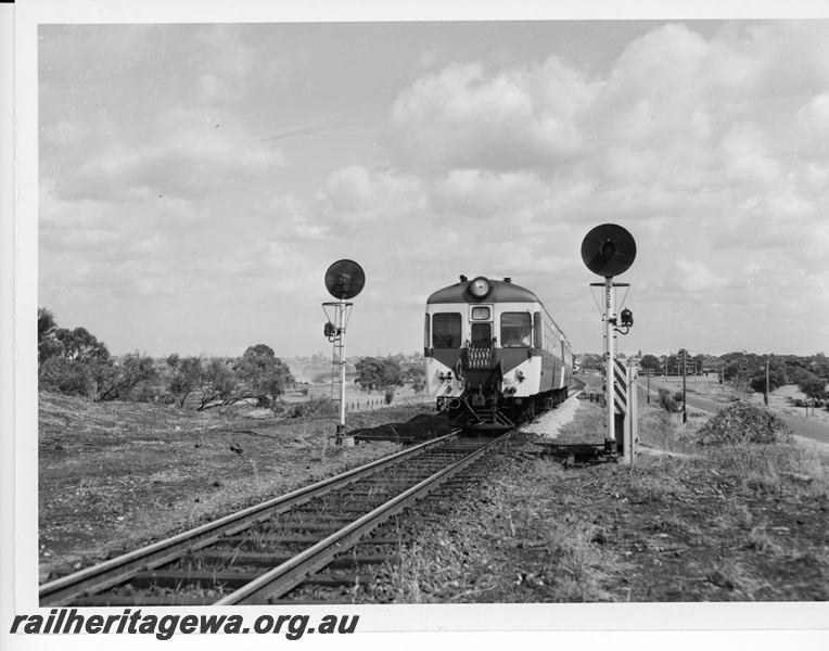 P10597
ADA Class suburban trailer car at the head of a 2 car train passing a set of 3 aspect signals at Rivervale.
