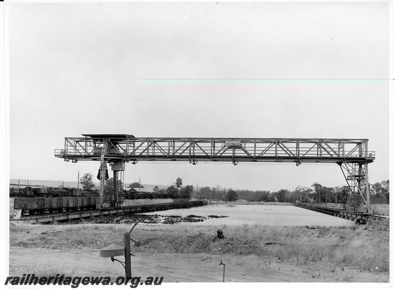 P10601
1 of 2. Underwater coal storage dam at Midland Junction. Gantry used to reclaim coal for locomotive use. Wagons alongside crane possibly being loaded for country depots.
