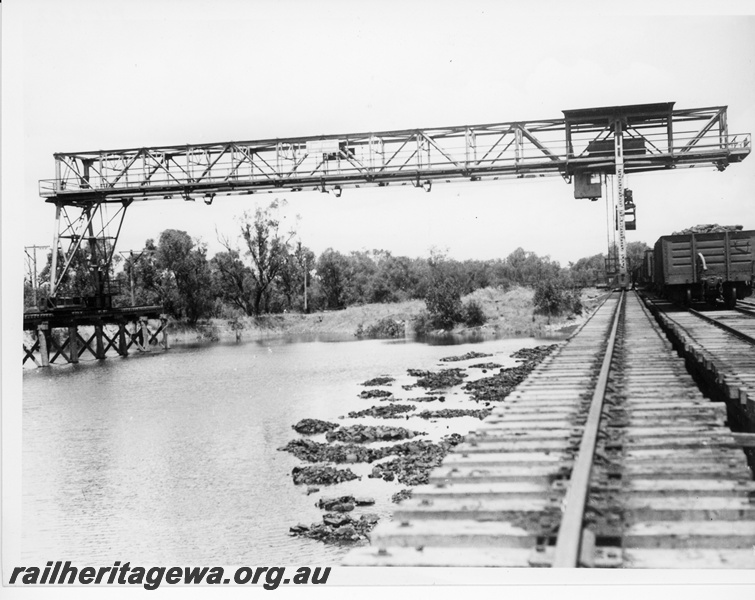 P10602
2 of 2. Underwater coal storage dam at Midland Junction. Gantry used to reclaim coal for locomotive use. Wagons alongside crane possibly being loaded for country depots.
