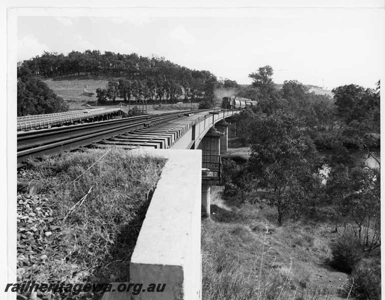 P10630
An unidentified RA Class narrow gauge diesel locomotive at the head of a woodchip train enroute from Manjimup to Bunbury crossing the Blackwood River bridge at Bridgetown, PP line.
